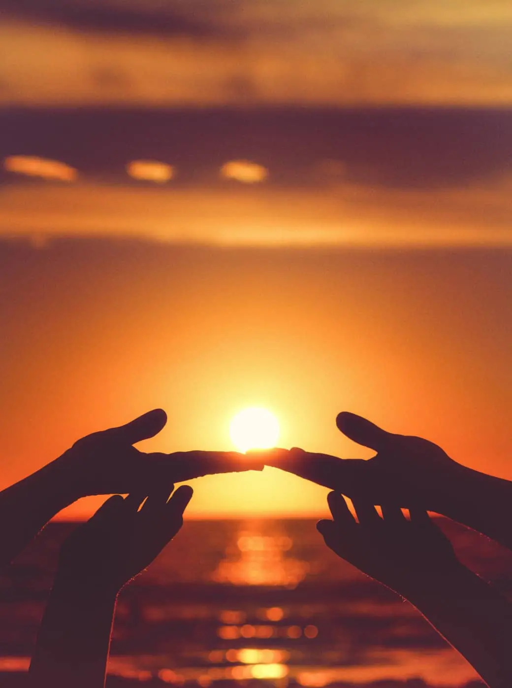 silhouette of hands at sunset